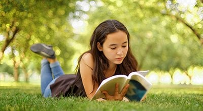 teen reading outside